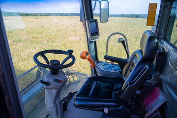 View of the field of corn from the cab of a combine harvester on a sunny day.