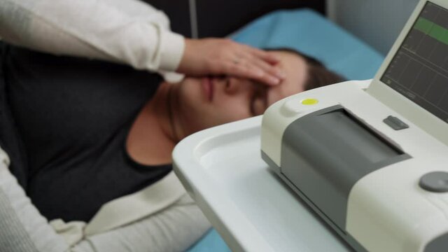Young Pregnant Woman On Hospital Couch During Medical Control Cardiotocography. Visit Gynecologist Doctor At Clinic For Pregnancy Consultant. Examine Expectant Belly Baby Mother Healthcare Check Up