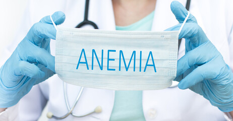 Doctor holding protective mask with text ANEMIA, medical concept