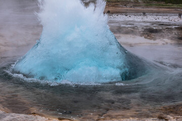 Geysir in Iceland bubbles up with boiling hot water.  A natural phenomenon