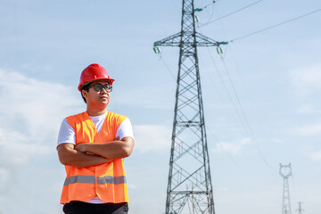 Asian electrical engineers worker in standard safety uniform standing at a power station to working...