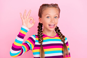 Photo of cheerful positive little lady fingers show okey sign wear striped shirt isolated pink color background