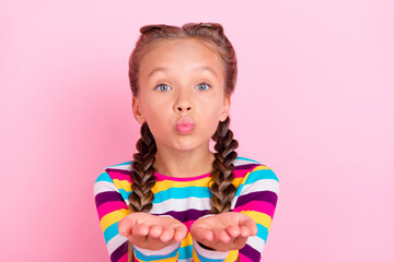 Photo of romantic lovely small lady hold palms send air kiss wear striped shirt isolated pink color background