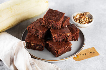 zucchini brownies with walnuts, on a plate, napkin, horizontally
