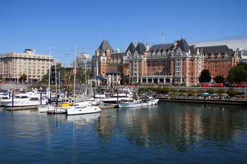 Victoria harbor with the traditional hotel and floating boats on a sunny day