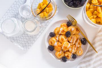 Dutch mini pancakes called poffertjes with blackberries and apple compot