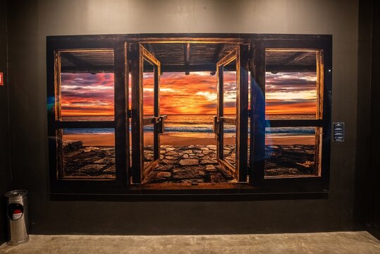 Tulum, Mexico. May 25, 2021. Beautiful picture of open window with idyllic seascape during sunset on display at exhibition center or art gallery