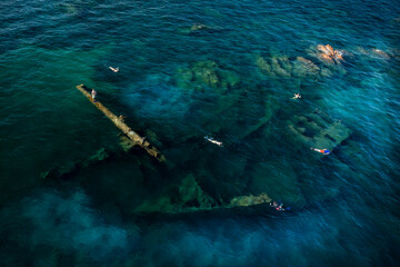 View from above, stunning aerial view of some people swimming and snorkeling around the Chrisso...
