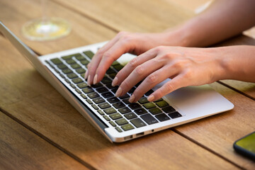 Close-up of woman's hand while typing on laptop