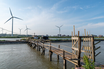 Coastline wind turbine under blue sky