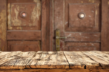 Old wooden dilapidated door in brown color with light shadows