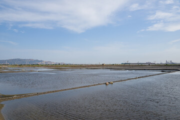 A road piled up on saline alkali land, a salt pond