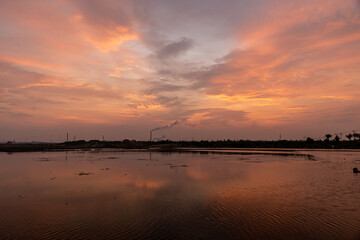 The sunset glow dyed the sky and the water surface of the saline alkali land red