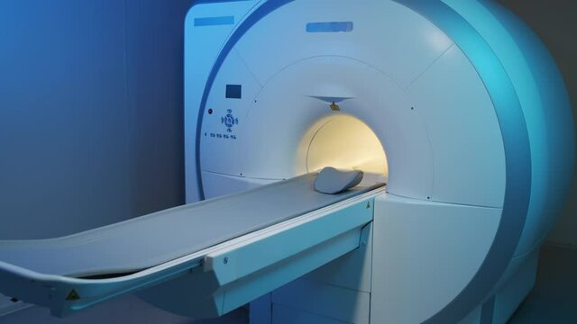 No people overview of high-tech MRI machine in radiology room with blue lighting