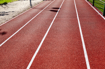 Fototapeta premium Red treadmill on sport field. Running track on the stadium