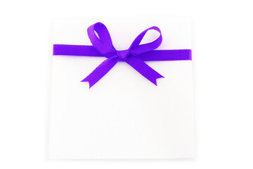 Sheet with purple holiday bow on white background