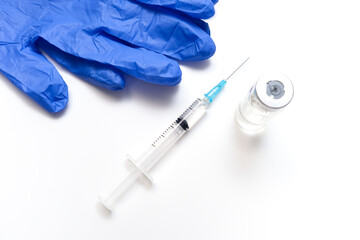 Covid 19 vaccination concept, viral and syringe with vaccine on a white table