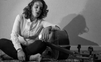 Mujer de mediana edad posando con violonchelo.