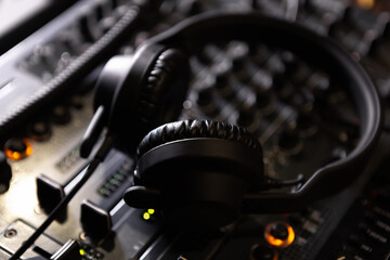 Dj headphones on sound mixer device on stage in night club. Listen and mix music with professional stereo headphone monitors