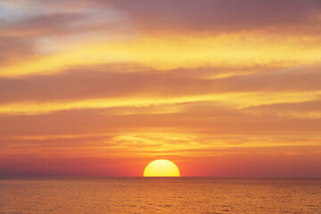 Naklejka na ściany i meble Big sun and sea sunset background.