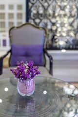 Purple plastic flowers in a glass vase decorate the living room of a luxury home