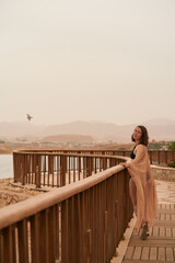 Pretty woman posing in Egypt hotel. Young caucasian woman in black swimsuit and golden dress