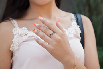 Woman wearing luxury ring standing on the street. Fashion concept.