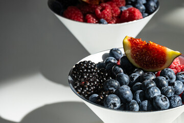 Various berries in a white bowl are ready to eat