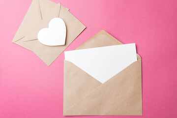The concept of a romantic love letter for Valentine's Day. A kraft envelope with a blank sheet of...