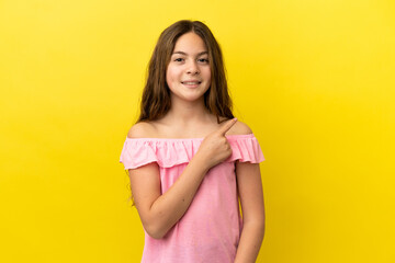 Little caucasian girl isolated on yellow background pointing to the side to present a product