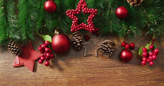 Video of christmas decorations with stars and copy space on wooden background