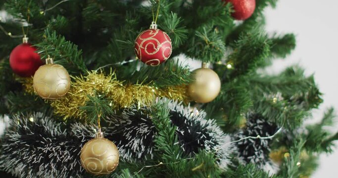 Video of christmas tree decorated with baubles on white background