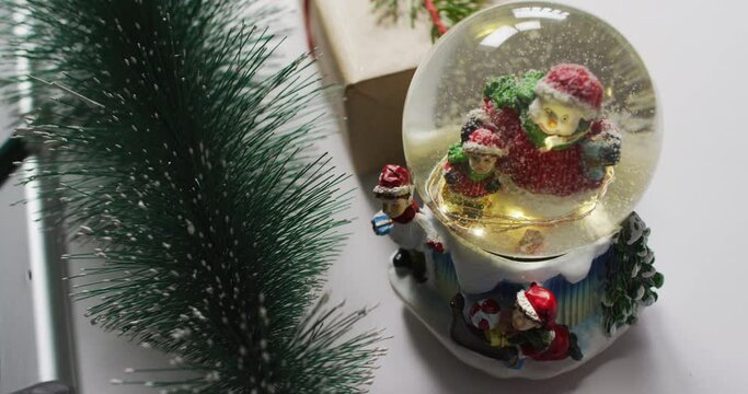 Video of christmas decorations with snow globe on white background