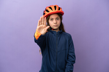 Little caucasian girl isolated on purple background making stop gesture