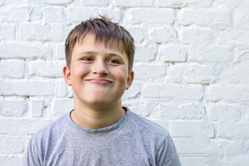 funny smirk on face of teenager. boy squeezed lips and bent over with shoulders down.