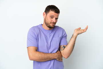 Young Brazilian man isolated on white background having doubts