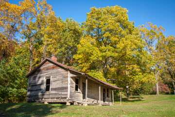 Fototapeta premium Abandoned old rural wooden building surrounded by trees