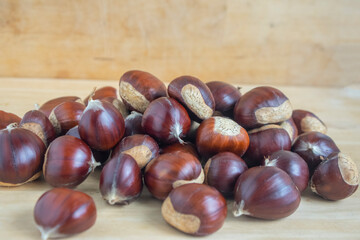 Fresh castanea sativa fruits on the table, sweet chestnuts ready for cooking, tasty brownish nuts marrons