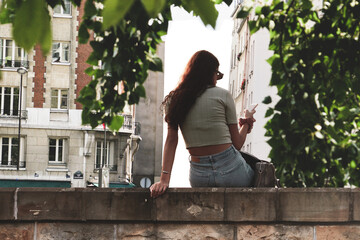Piękna młoda kobieta przegląda smarfona w Paryżu