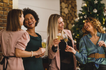 Four Multiracial Female Friends Having Fun And Make Toast As They Celebrate At Home Christmas Party