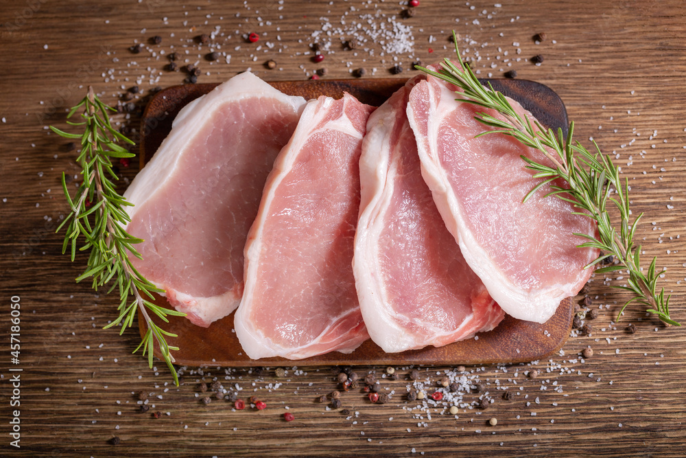 Poster Fresh meat. Pork chops with rosemary and spices on wooden board