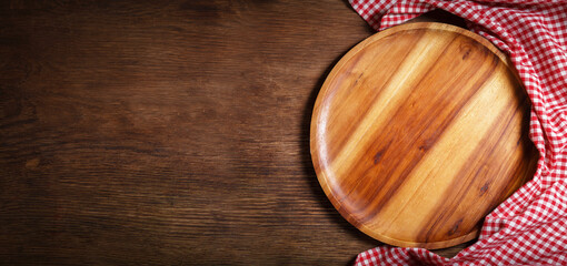 empty wooden plate with red tablecloth on a wooden background