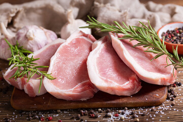 Fresh meat. Pork chops with rosemary and spices on cutting board