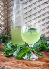 Glass of lemonade made from green basil and lemon