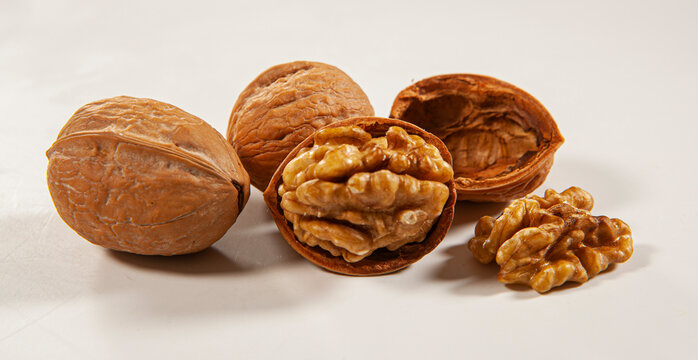 Grupo de nozes fechadas e abertas em fundo branco para recorte.