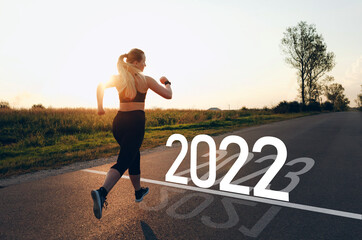  Sporty girl who runs towards year 2022, leaving behind the year 2021.  New year 2022 with new...