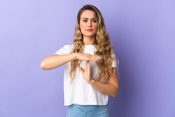 Young Brazilian woman isolated on purple background making time out gesture