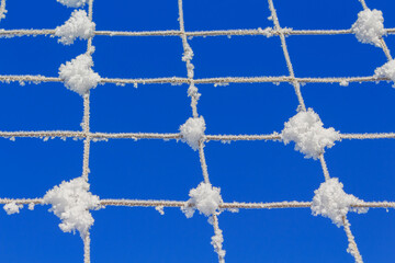Volleyball net covered with snow. Nature's minimalism. 