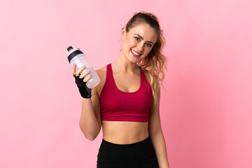Young Brazilian woman isolated on pink background with sports water bottle