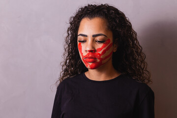 Afro woman with handprint on her mouth in favor of awareness of feminicide. Domestic violence